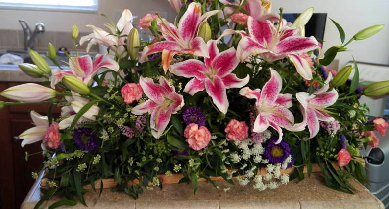 floral arrangement with Starfighter lilies and carnations.